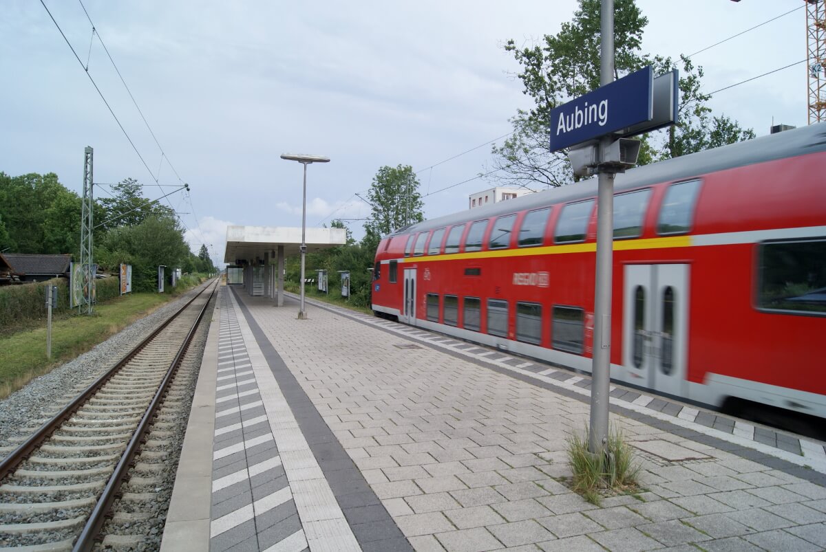 Am Außenbahnsteig Aubing hält ein Regionalzug. Im Hintergrund sind Bäume.